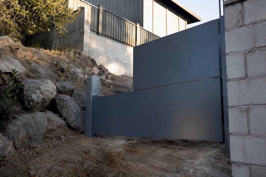 Terraced two-panel gate on uneven rocky slope