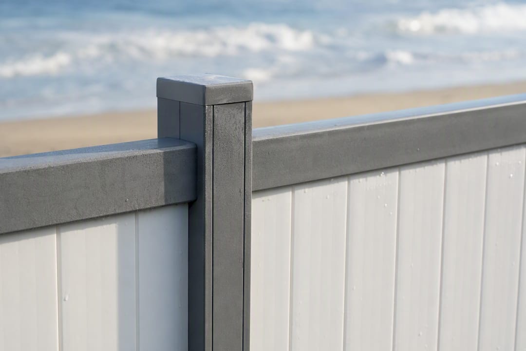 Aluminum frame holding vinyl fence panels near pool